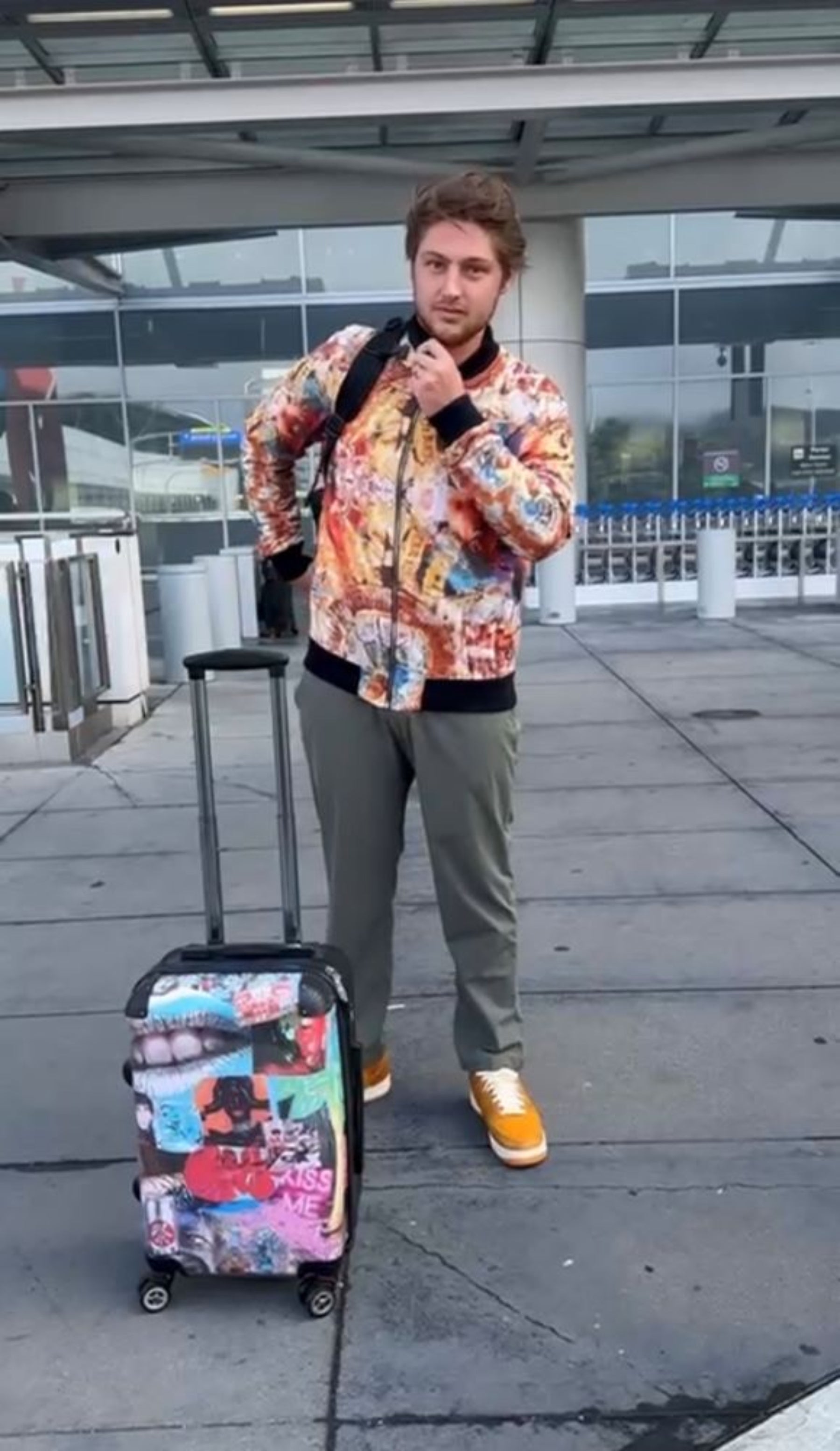 Person in colorful jacket with patterned suitcase at an airport